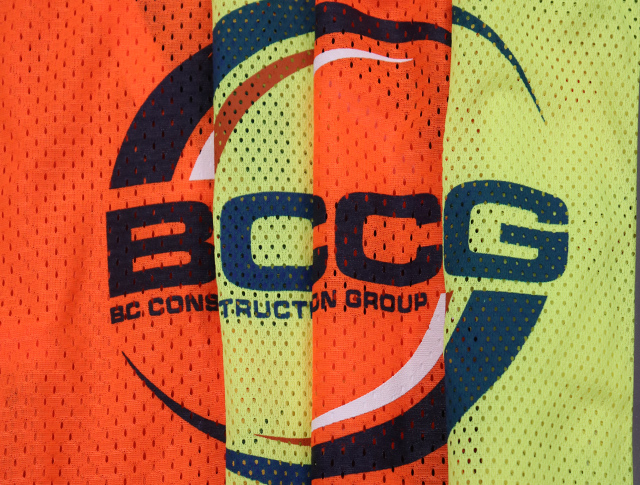 Four BCCG construction vests in neon yellow and orange.