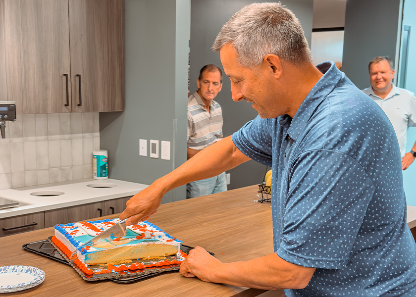 Woody cutting his retirement party cake