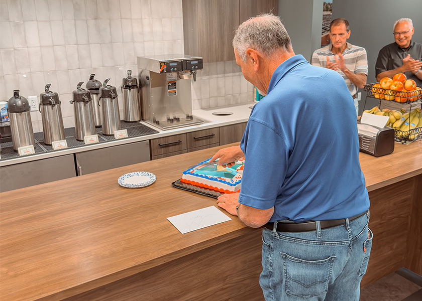 Woody cutting his retirement party cake