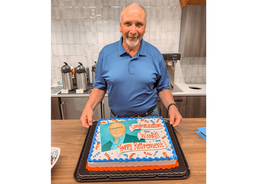 Woody posing with his retirement party cake